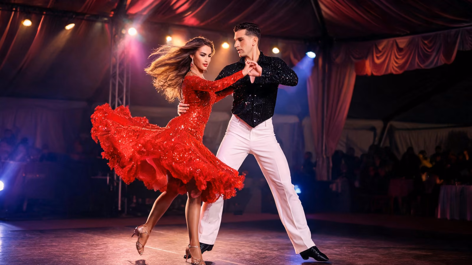Espectáculo de salsa con bailarines en escenario con vestuario brillante de lentejuelas